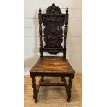 A single oak Jacobean style hall chair with a carved lion back and turned supports finishing in