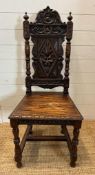 A single oak Jacobean style hall chair with a carved lion back and turned supports finishing in