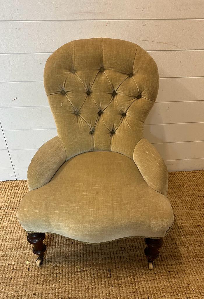 A Victorian button back nursing chair upholstered in a pale green velvet