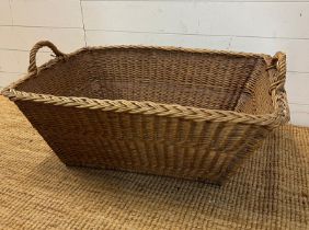 A large wicker laundry basket (H31cm W80cm D56cm)