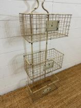 A farm house distressed finish wire wall, mounted three tier storage rack