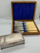 A cased set of fish knives and forks along with a white metal cigarette case