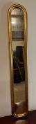 A long wooden framed gold painted oval hall mirror 114cm x 19cm