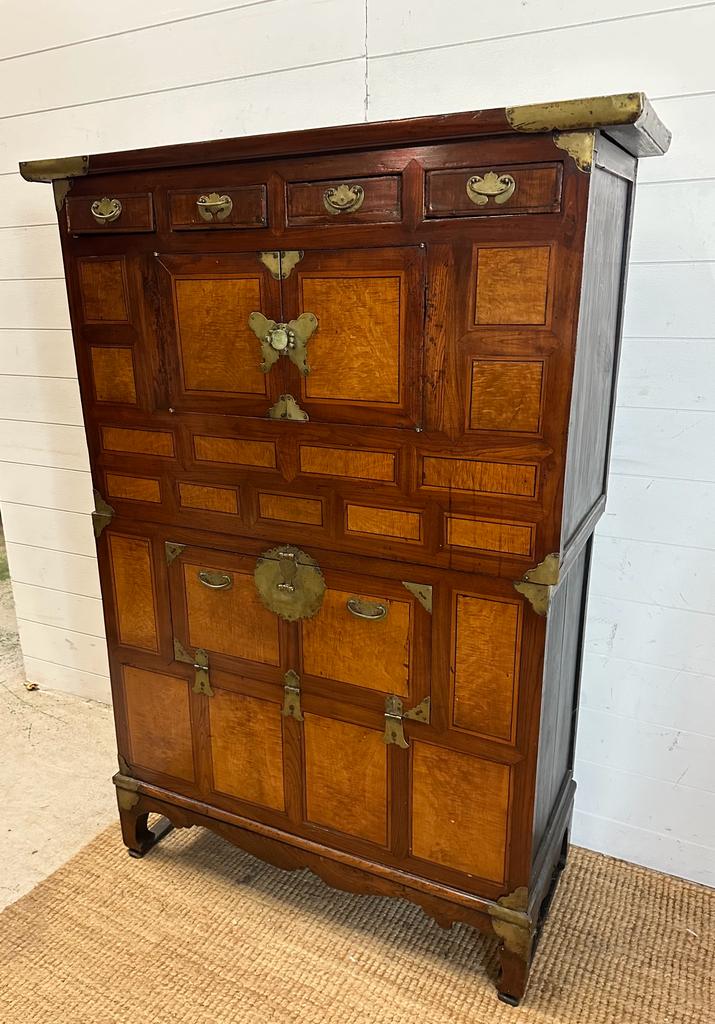 A Korean two toned cabinet comprising of two cupboards with four drawers over, brass hinges, handles