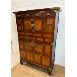 A Korean two toned cabinet comprising of two cupboards with four drawers over, brass hinges, handles