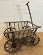 A vintage wooden garden trolley on wooden metal bound wheels