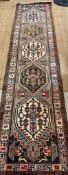 A beige ground wool runner with geometric boarder and Aztec style central 75cm x 309cm