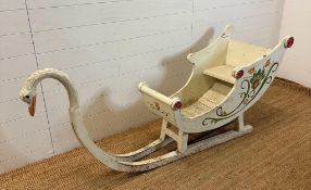 A hand painted swan sleigh, the sleigh is decorated with a hand painted floral motif and the runners