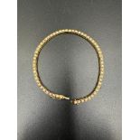 An 18ct gold and diamond line bracelet (19cm long and approximately 11.8g)