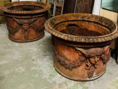 A pair of ornamental terracotta urns with classical style, decorated with a floral laurel joined