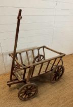 A vintage wooden dog cart or garden trolley with metal bound wheels