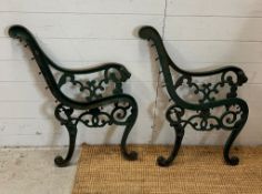 Cast metal bench ends with scrolling pattern and sweeping arms terminating with lion ends