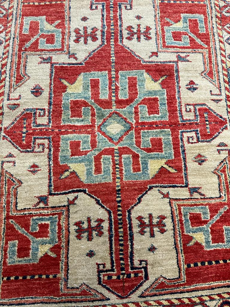 A red ground rug with a repeating Aztec pattern 123cm x 100cm - Image 2 of 4