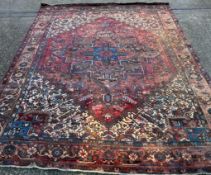 A large red ground rug with central star medallion 360cm x 262cm