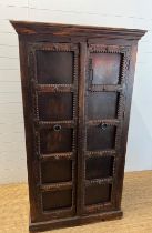 An oriental cabinet with two panelled doors opening to shelves and iron work handles (H174cm