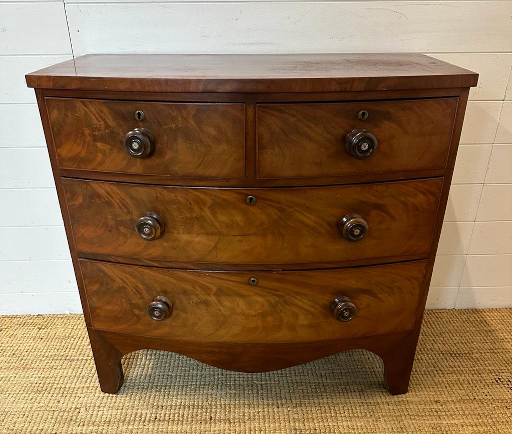 A Georgian style two over two bow fronted chest of drawers with mahogany top and flame mahogany