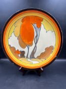 A Clarice Cliff plate in the autumn pattern with central hand painted scene enclosed in bands AF