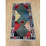 A hand knotted nomad rug in greens, reds and blues 153cm x 80cm