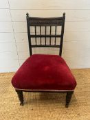 A Victorian dark wood bedroom chair on castors with red upholstered seat AF