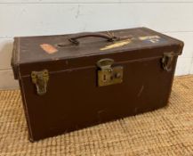 A vintage brown leather camera case with red velvet interior