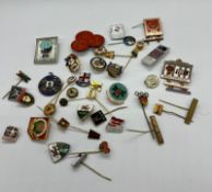 A collection of pin badges and medals mostly of a sporting theme