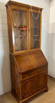 A yew bureau bookcase comprising of a glazed two shelf bookcase and a red leather topped bureau with