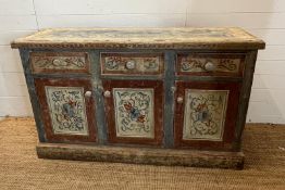 A vintage pine sideboard comprising of three drawers and three cupboards under with painted floral