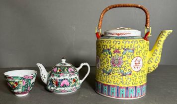 A Chinese tea pot and cup in the famille rose palette and a larger "Longevity" teapot