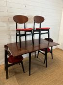 A mid century drop leaf dining table and four ebonised red upholstered dining chairs. Length 140