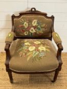 A needle work upholstered Easy chair with carved top rail and fluted down swept arms