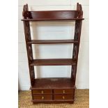A mahogany four drawer bookcase or wall rack with carved supports