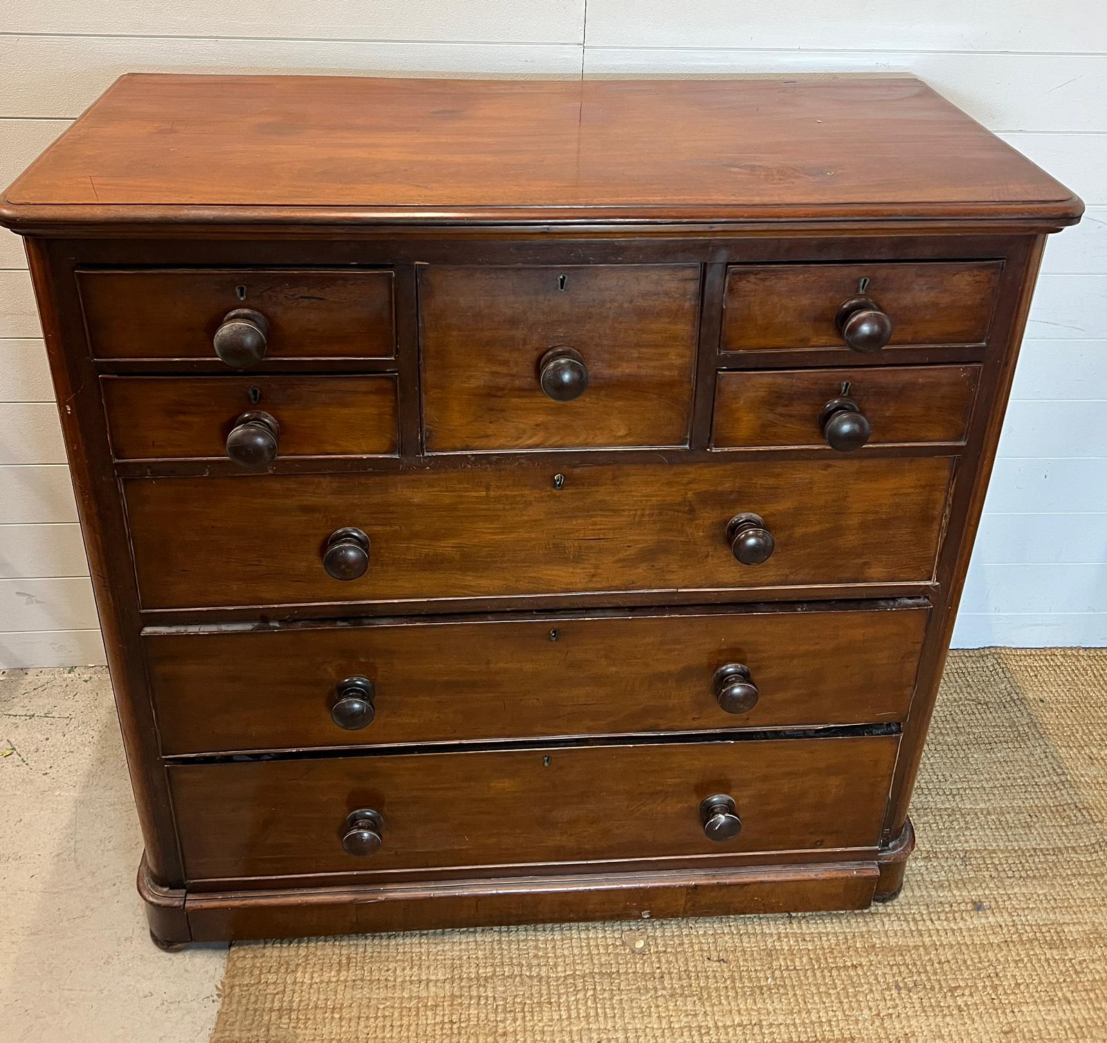 A mahogany chest of drawers with four short and one centre drawer followed by three long (H120cm