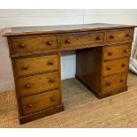 An oak pedestal desk with long central drawer flanked by four shorter drawers to left and right (