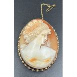 A 9ct gold Cameo of a lady in classical pose, 48mm long.