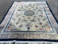 A large beige ground rug with a blue boarder and central medallion 276cm x 386cm