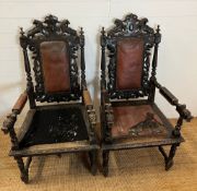 A pair of oak throne chairs, gothic hall chairs with carved swags and scrolls, flanked by tapering