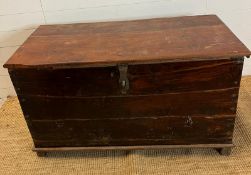 A large wooden chest with wrought iron lock on wooden feet (H70cm W121cm D60cm)