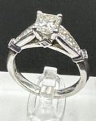 A diamond single stone ring with diamond set shoulders and mount. Princess cut diamond, measuring