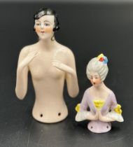 Two porcelain doll head figures, one in a 1920's style.