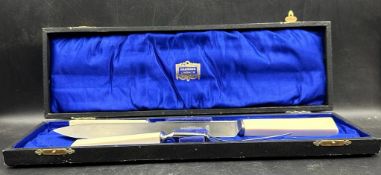 A boxed stainless steel carving set from Harrods of London to include knife, fork and steel