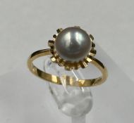 An 18ct gold ring with single central pearl, approximate size O1/2, approximate weight 3.4g.