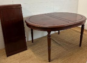 An extendable oval mahogany dining table with brass string inlay on turned legs with an accompanying