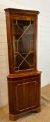 A glazed corner cabinet with cupboard under