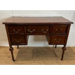 A mahogany knee hole dressing table with central drawer flanked by two shorter drawers, turned