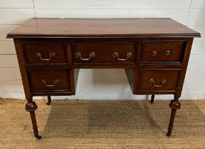 A mahogany knee hole dressing table with central drawer flanked by two shorter drawers, turned