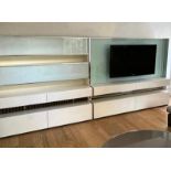 A wall media unit with gloss and chrome frame and frosted glass along with a flat screen TV (each