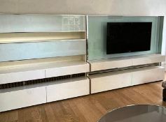 A wall media unit with gloss and chrome frame and frosted glass along with a flat screen TV (each