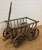 A vintage wooden dog cart or garden trolley with metal bound wheels