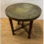 A brass tea table on fluted wooden legs