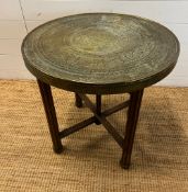 A brass tea table on fluted wooden legs